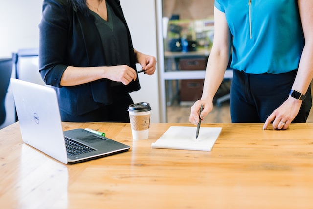 two people in an office looking at a document