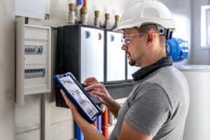 electrical technician looking focused while working switchboard with fuses