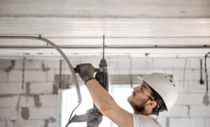 handyman in a home using jackhammer on ceiling