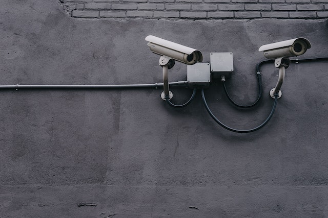 two cctv cameras on a grey wall
